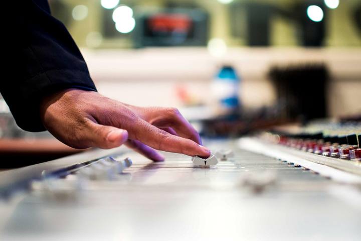 Hands working at a mixing desk.