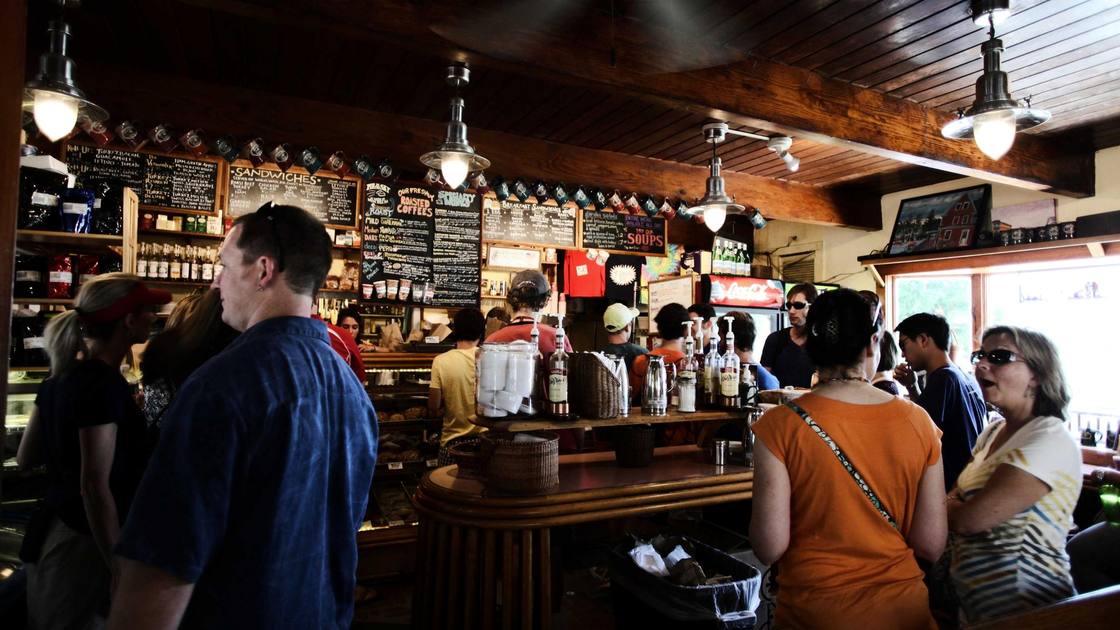 Inside a bar with customers at the counter, warm light.