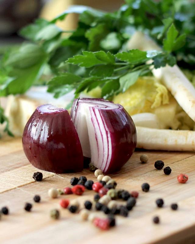 Vegetables and spices on a wooden chopping board.